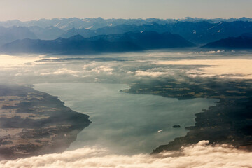 Aerial view of silhouetted mountain range by river with landscape and clouds