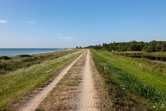 Dirt road passing through landscape at seashore, Schleswig-Holstein, Germany