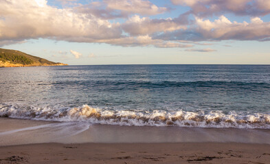 Beautiful seascape with small foamy waves and the sky with white clouds. Elba Island, Italy