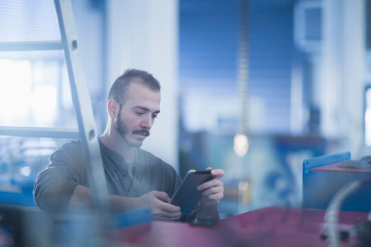 Young male engineer using a digital tablet in an industrial plant, Freiburg im Breisgau, Baden-W&uuml;rttemberg, Germany