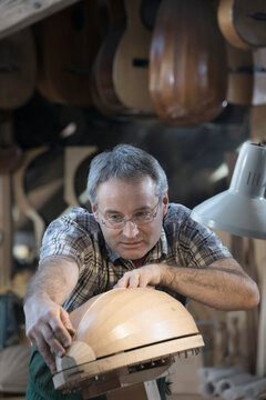 Craftsman manufacturing lute at workshop
