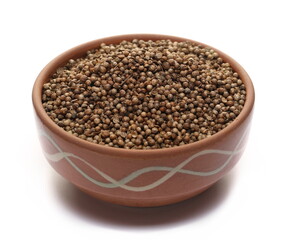 Pile coriander seeds in clay pot isolated on white 