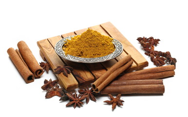 Curry pile in metal plate with cinnamon sticks and star anise isolated on white