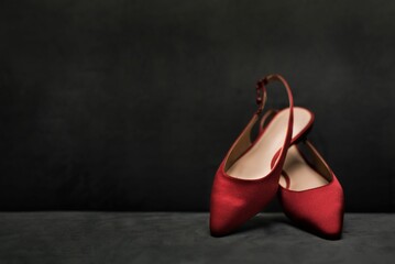 Pair of red slingback shoes set on one another on a dark background