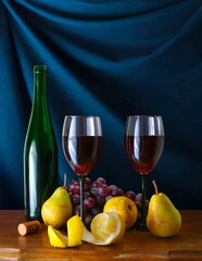 still life with fruit and wine on a blue background