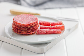 Sliced mexican salami with beans on plate.