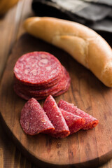 Sliced mexican salami with beans on cutting board.