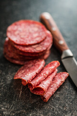 Sliced mexican salami with beans on  black table.