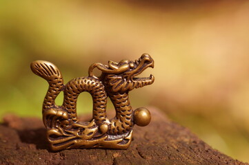 Dragon figurine close-up on a colored background. East Asian culture. A spiritual symbol.