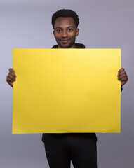 young man showing blank cardboard empty copy space yellow board poster presentation display