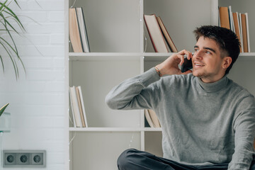 young man at home with mobile phone or smartphone