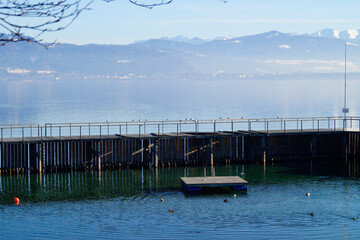 empty open air swimming pool on Lindau island on wintery lake Constance (Bodensee) with Austrian...