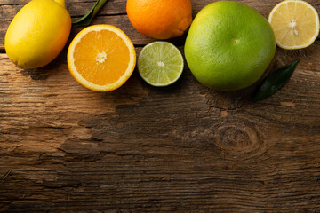 Fototapeta na wymiar Fruits, lemons, oranges, limes and grapefruit on rustic wooden table