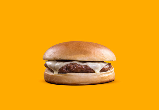 delicious fast food cheeseburger isolated on yellow background