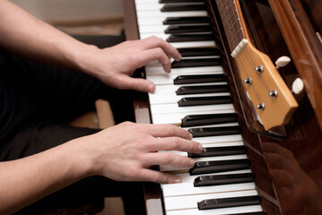 A young man plays the piano, remembers his favorite hobby - playing the piano from childhood, already in adulthood, a guy plays from time to time for pleasure