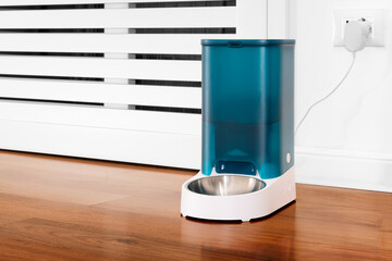 Close-up of an automatic dry cat food dispenser. Pet feeding concept remotely with wifi and online scheduling. Elegant home dispenser. Distance feeding for domestic cats.