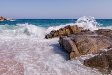 Fototapeta na wymiar Huge waves crash against the rocks at Fenals Beach in Lloret de Mar. Catalonia