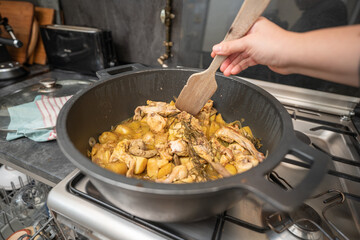 Rabbit meat cooking in a big pan on a kitchen indoor