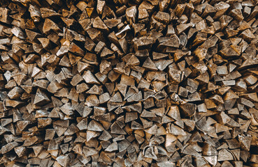 Chopped firewood pile. Woodpile wall. Heap of old dry pine woods. Brown textured background....