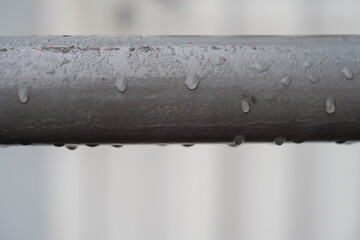 gouttes de pluie sur une rambarde en métal peint macro