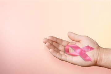 Human hand hold pink ribbon. Breast cancer concept