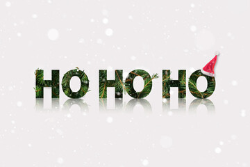 Santa ho ho ho sound made of a fir branch with Santas hat in the end. Winter Christmas theme with snow.