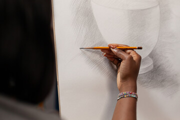 Hand of unrecognizable african american drawing artist making pencil strokes on white surface at...