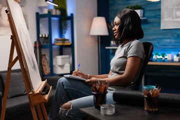 African american woman with artistic abilities appreciating completed pencil drawing in modern art...