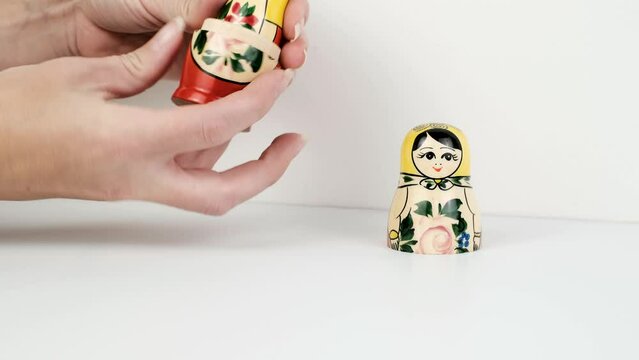 Hands opening set of traditional Russian wooden babushka dolls - matrioshka. Stacking or nested doll typical to Russia. Matrioshka brain concept.