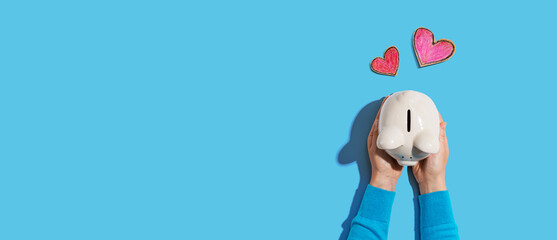 Person holding a piggy bank with hearts