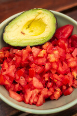 diced tomato and avocado in a bowl ready to prepare guacamole