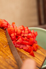 person placing diced tomatoes for cooking