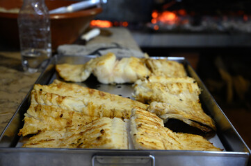 Cod fish salted bacalhau grilled on olive wood firewood grill in small village restaurant in Portugal