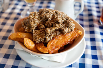 Scottish traditional snack food, hand cut potato chips topped with haggis and gravy