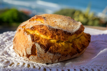 Portugeese homemade oven baked yellow corn bread served outdoor with view on blue Atlantic ocean in...
