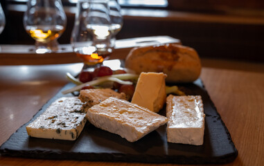 Pairing of scotch whisky and farmers scottish cheeses cheddar, stilton, blue cheese, brie, tasting of whiskey and cheese in Edinburgh, UK