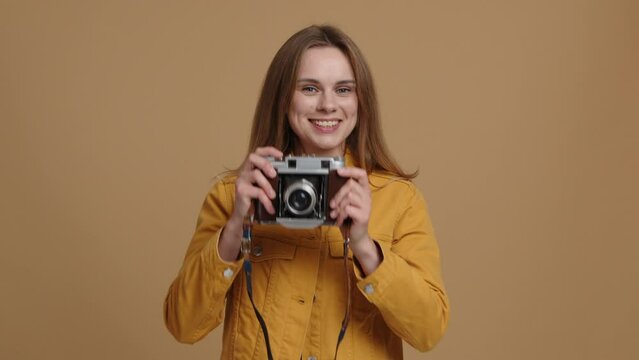 Close-up shot of female photographer looking at camera. Caucasian, young woman taking pictures in the studio. High quality 4k footage