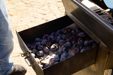 Roasting chestnuts on fire, Portuguese street food in autumn, Lisbon, Portugal