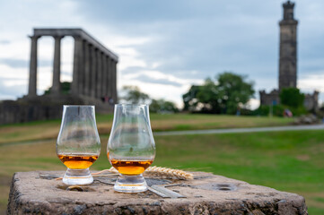 Tasting of single malt scotch whisky in glasses with view from Calton hill to new and old parts of Edinburgh city in rainy day, Scotland, UK