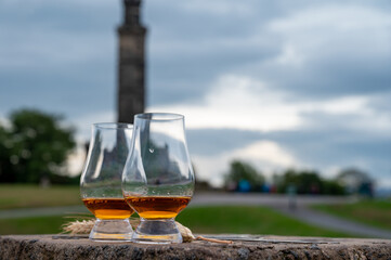 Tasting of single malt scotch whisky in glasses with view from Calton hill to new and old parts of Edinburgh city in rainy day, Scotland, UK