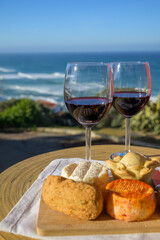 Food and wine pairing, red dry Portuguese wine, fish pastry, pie, variety of goat, sheep, cow cheeses made with paprika, herbs in Portugal