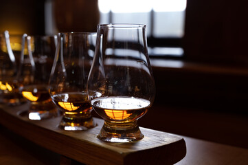 Flight of single malt scotch whisky in glasses served in whiskey bar in Edinburgh, UK