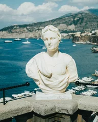Fotobehang Historisch gebouw Vertical shot of a greek bust statue outdoors with a seascape in the background