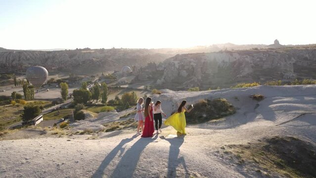Girls drink champagne in Cappadocia, Hot air balloons background, Sunset view