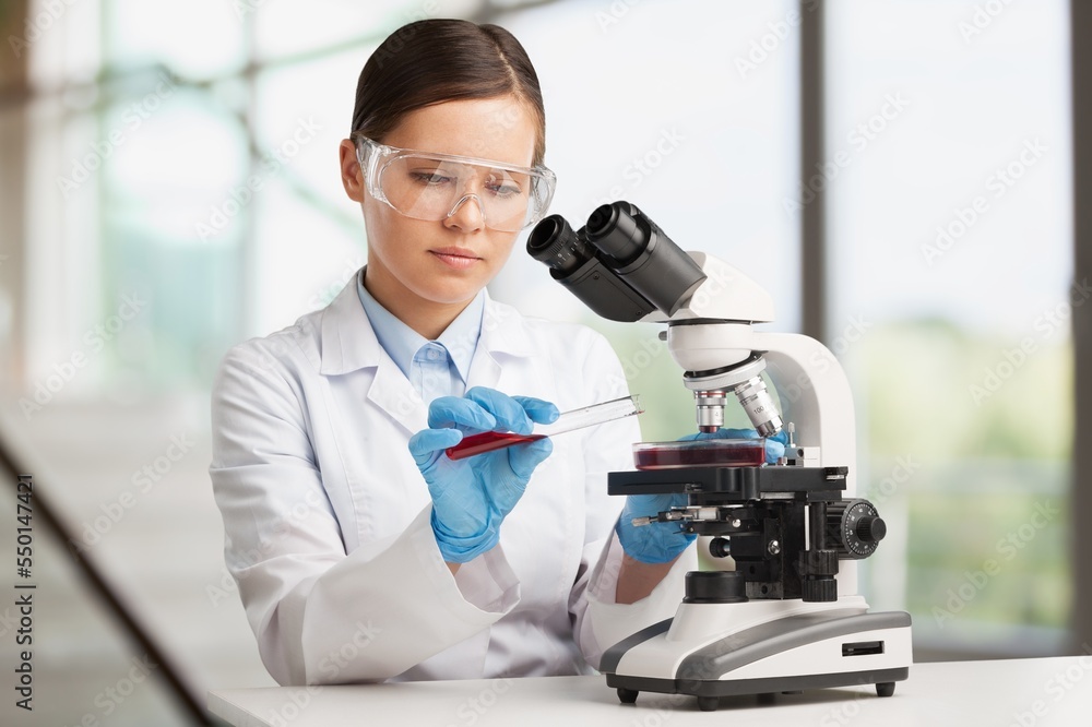 Wall mural Young doctor with sample tube in lab