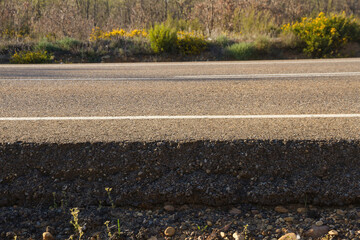 Cross sectional view of the asphalt  base layer  or firm with gravel and asphalt of a road at ground level  