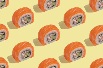 Japanese sushi with salmon, dragon rolls on a pastel yellow background. Pop art, background, pattern.