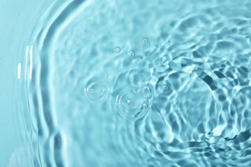 Closeup view of water with rippled surface on light blue background