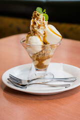This image shows a delicious caramel parfait dessert on a wooden table in Japan.