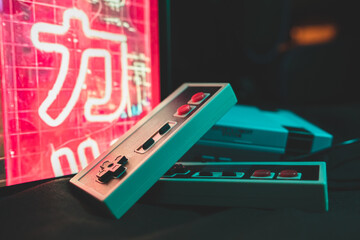 A close up of a retro console and retro controllers in retro 80s environment with colors at night...
